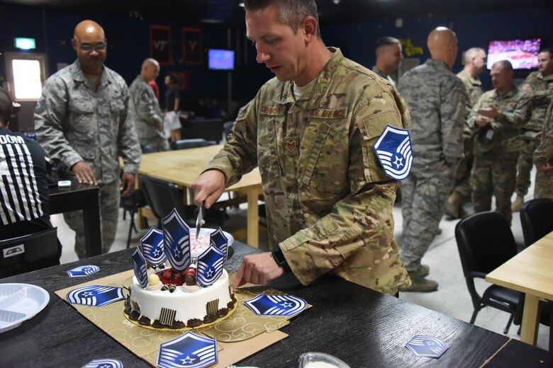 Tech. Sgt. Peter H. Demkow Jr., the NCOIC of the Intransit Munitions Facility with the 386th Expeditionary Logistics Readiness Squadron, cuts the cake honoring Demkow on his selection for master sergeant at an undisclosed location in Southwest Asia, May 24, 2017. The 386th Air Expeditionary Wing Top Three Council hosted a master sergeant release party to celebrate the five technical sergeants that were selected for master sergeant.  (U.S. Air Force photo/Tech. Sgt. Jonathan Hehnly)
