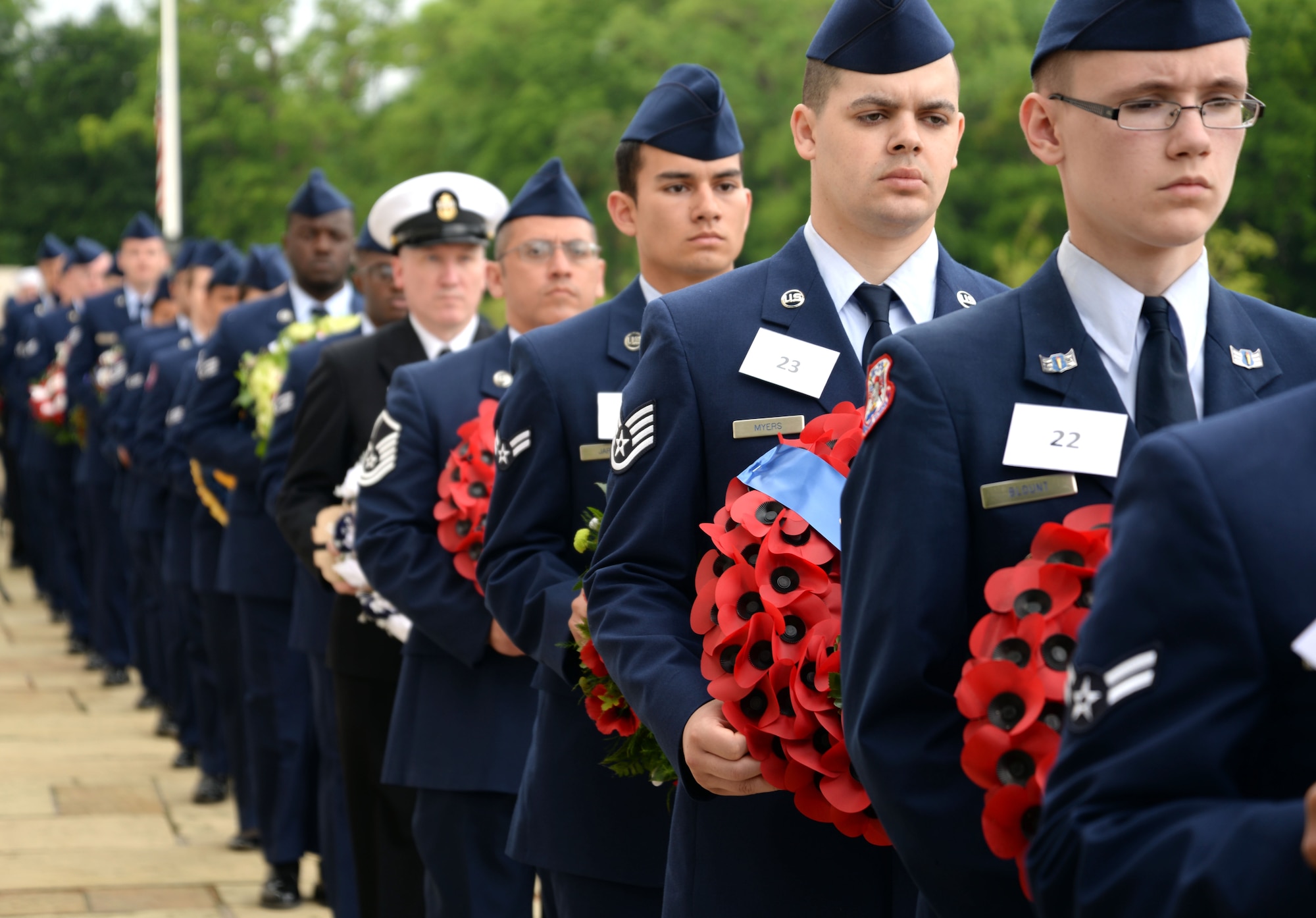 Dozens of Airmen and other U.S. Military Service members carry wreaths donated from several organizations to lay during the Madingley Memorial Day Ceremony May 29, 2017, at Madingley Memorial Cemetery in Cambridge, England. This year volunteers’ collected more than 4,000 portraits of veterans to lay at corresponding headstones within the cemetery. (U.S. Air Force photo by Senior Airman Christine Groening) 