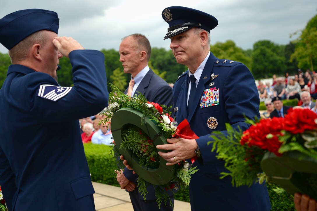 U.S. Air Force Maj. Gen. Timothy G. Fay, Headquarters U.S. Air Forces in Europe and Air Forces Africa director, operations, strategic deterrence and nuclear integration, accepts a wreath to lay at the Wall of the Missing at Madingley Memorial Cemetery on May 29, 2017, in Cambridge, England. The event is held annually and includes full military honors to remember all fallen heroes. (U.S. Air Force photo by Senior Airman Christine Groening) 