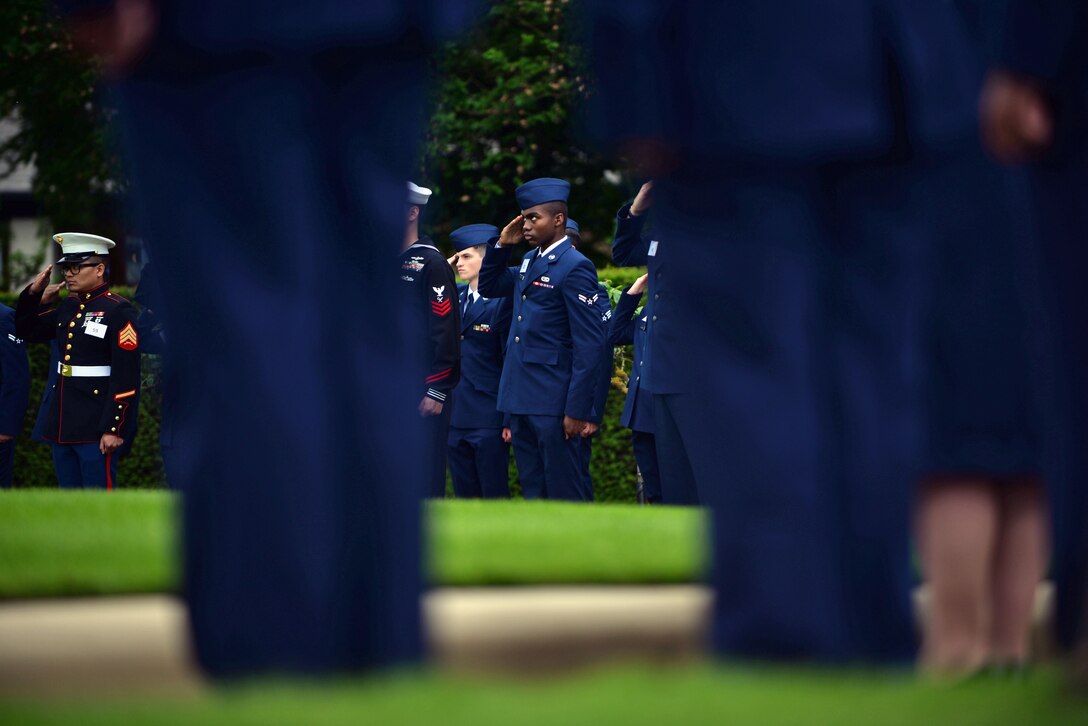 U.S. Service members salute the U.S. flag during the Madingley Memorial Day ceremony May 29, 2017, at Madingley Memorial Cemetery in Cambridge, England. The cemetery is the final resting place for thousands of American veterans. (U.S. Air Force photo by Senior Airman Christine Groening)