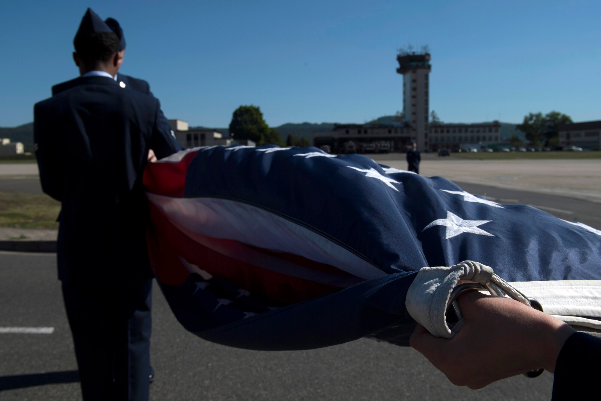 U.S. Air Force Staff Sgt. Clayton Hamrick, 76th Airlift Squadron communication systems operator, and U.S. Air Force Airman 1st Class Corey Fuller, 86th Operations Support Squadron, host aviation resource management, fold the American flag during the 86th Operations Group’s Memorial Retreat Ceremony on Ramstein Air Base, Germany, May 26, 2017. During the ceremony, seven Airmen lowered and folded the American and German flags during the playing of the respective national anthems, while the remainder of the Airmen stood in formation and saluted. (U.S Air Force photo by Senior Airman Tryphena Mayhugh)