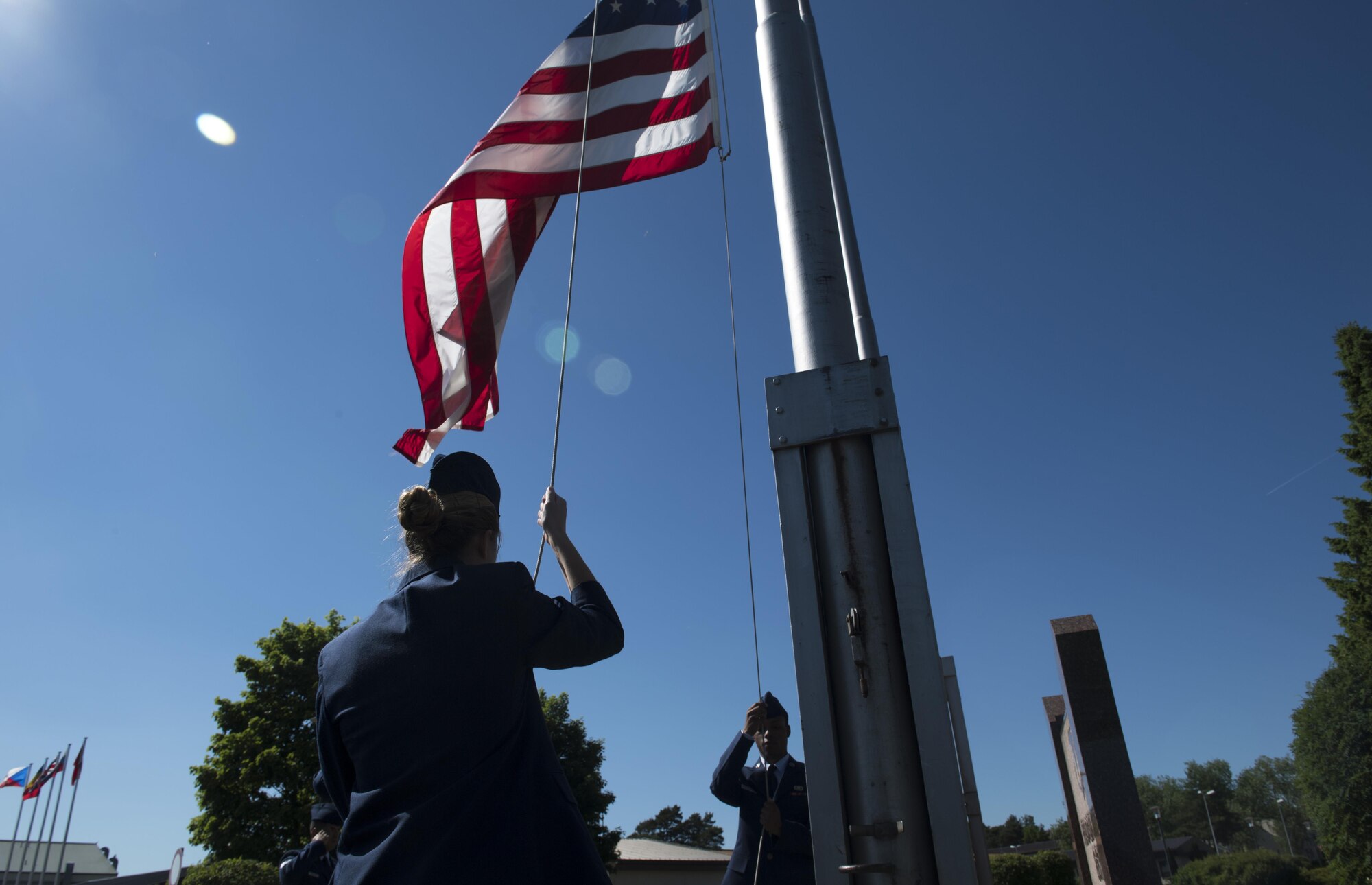 U.S. Air Force Senior Airman Nikki Erling (left), 86th Operations Support Squadron airfield systems technician, and U.S Air Force Airman 1st Class Corey Fuller, 86th OSS host aviation resource management, lower the American flag during the 86th Operations Group’s Memorial Retreat Ceremony on Ramstein Air Base, Germany, May 26, 2017. Airmen from four different squadrons within the 86th OG participated in the ceremony. (U.S Air Force photo by Senior Airman Tryphena Mayhugh)