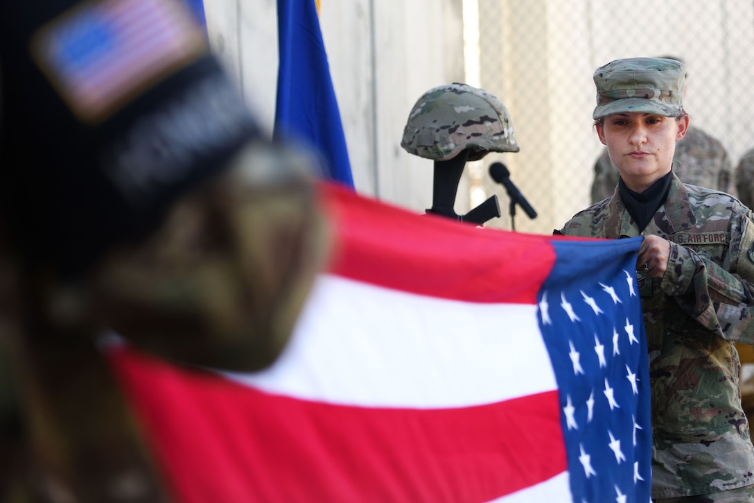 Air Force Tech. Sgt. Bajame Kirby folds the American flag during a Memorial Day ceremony at Bagram Airfield, Afghanistan, May 29, 2017. Kirby is assigned to the 455th Expeditionary Force Support Squadron. Air Force photo by Staff Sgt. Benjamin Gonsier
