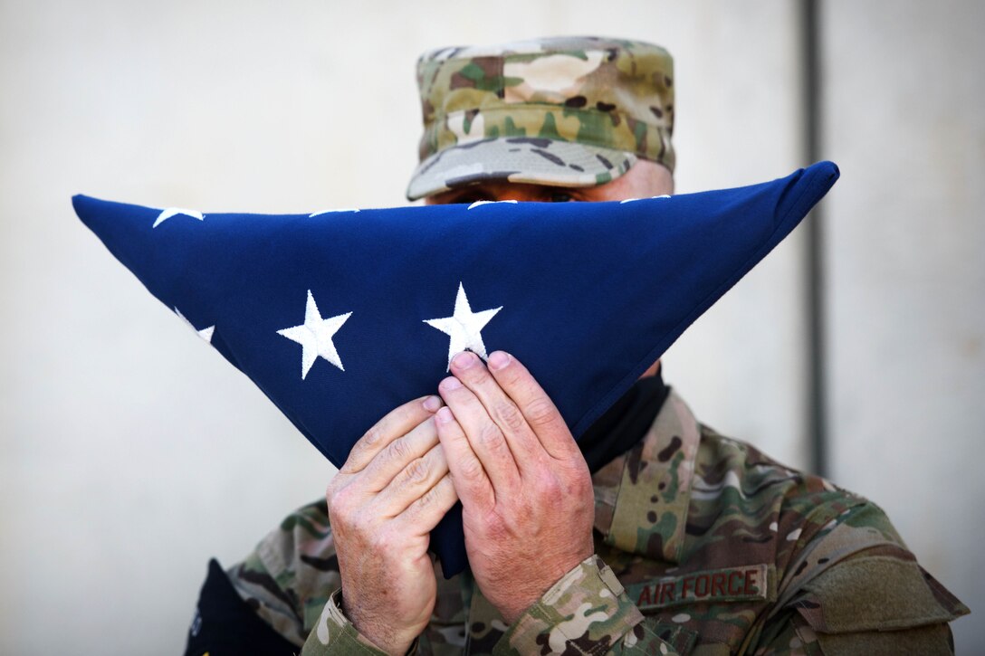 Air Force Senior Master Sgt. Michael Miller holds the American flag during a Memorial Day ceremony at Bagram Airfield, Afghanistan, May 29, 2017. Miller is assigned to the 455th Expeditionary Communications Squadron. Air Force photo by Staff Sgt. Benjamin Gonsier