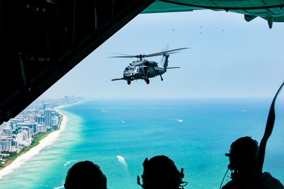Aircrew watch an HH-60G Pave Hawk helicopter from the back of an HC-130P/N Combat King aircraft during the National Salute to America’s Heroes Air and Sea Show at Miami Beach, Fla., May 26, 2017. The airmen are assigned to the 129th Rescue Wing. Air Force photo/Staff Sgt. Jared Trimarchi