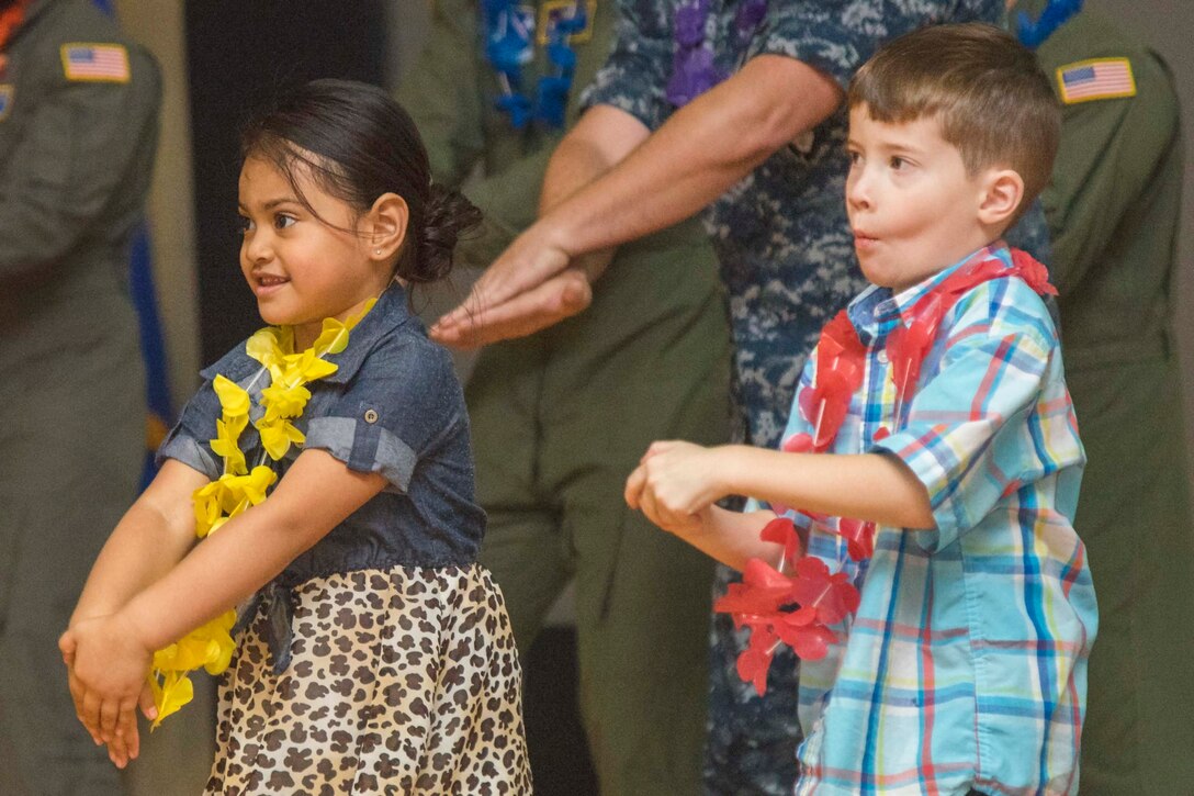 Amytheus Vaa, left, and Braeden O'Donnell, right, Asian American and Pacific Islander Heritage Month Culture Show attendees, participate in a hula dance during the show at Joint Base Andrews, Md., May 24, 2017. The event began with guest speaker, Amata Coleman Radewagen, U.S. congresswoman, followed by AAPI food and performances. (U.S. Air Force photo by Airman 1st Class Valentina Lopez)