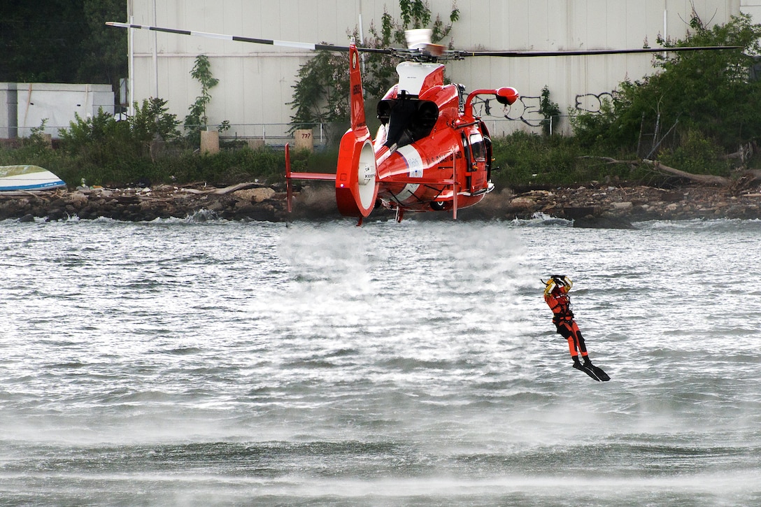 A Coast Guard rescue swimmer jumps from HH-65 Dolphin helicopter during a search and rescue demonstration off Staten Island Pier during Fleet Week New York in New York City, May 27, 2017. Coast Guard photo by Petty Officer 2nd Class Michael Himes