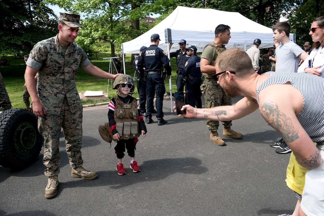 Marine Corps Lance Cpl. Dalton Mundy poses for a photograph with a child at Marine Day in Prospect Park during Fleet Week New York in New York City, May 27, 2017. Mundy is assigned to 2nd Battalion, 10th Marine Regiment, Special Purpose Marine Air-Ground Task Force New York. Marine Corps photo by Cpl. Erasmo Cortez III