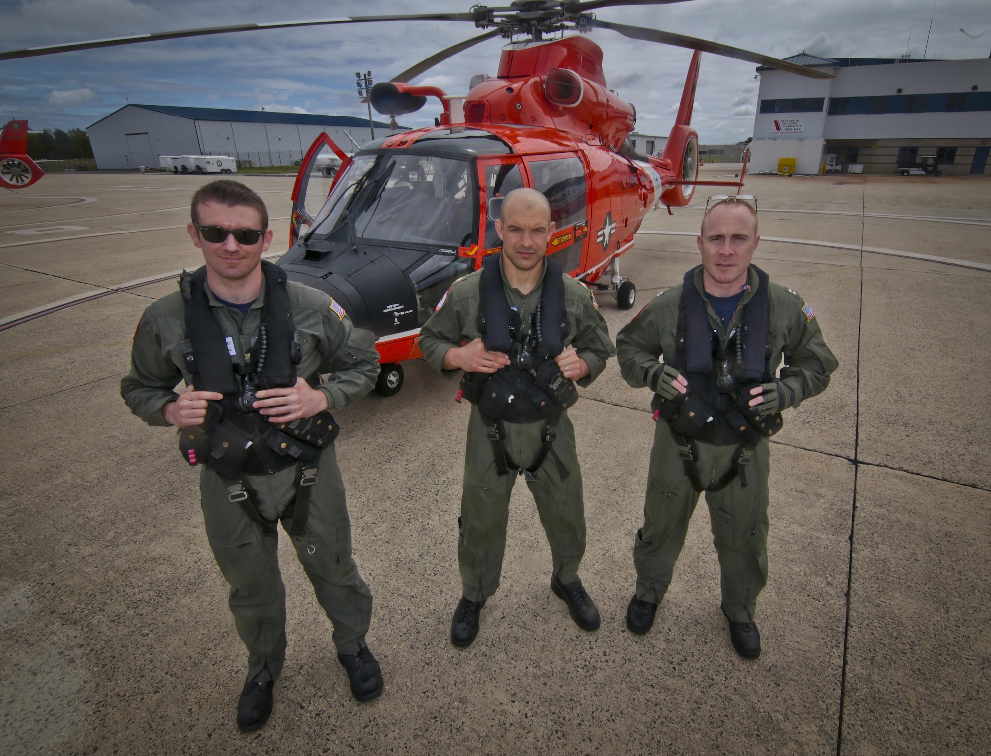 A U.S. Coast Guard HH-65C Dolphin helicopter crew from Coast Guard Air Station Atlantic City stand for a portrait before a mission during a three-day Aeropsace Control Alert CrossTell live-fly training exercise at Atlantic City International Airport, N.J., May 24, 2017. Representatives from the Air National Guard fighter wings, Civil Air Patrol, and U.S. Coast Guard rotary-wing air intercept units will conduct daily sorties from May 23-25 to hone their skills with tactical-level air-intercept procedures. (U.S. Air National Guard photo by Master Sgt. Matt Hecht/Released)