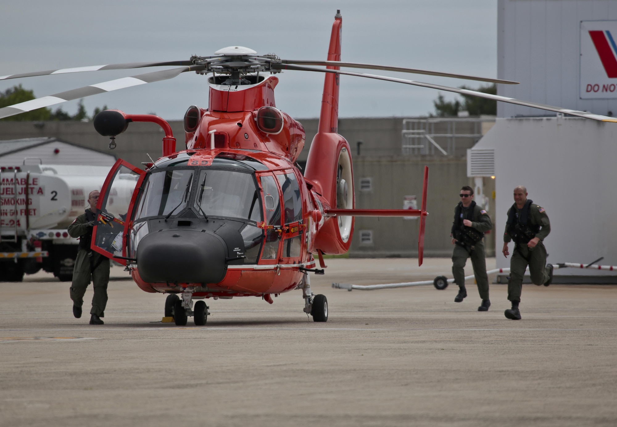 A U.S. Coast Guard HH-65C Dolphin helicopter crew from Coast Guard Air Station Atlantic City rushes to their aircraft after an alert during a three-day Aeropsace Control Alert CrossTell live-fly training exercise at Atlantic City International Airport, N.J., May 24, 2017. Representatives from the Air National Guard fighter wings, Civil Air Patrol, and U.S. Coast Guard rotary-wing air intercept units will conduct daily sorties from May 23-25 to hone their skills with tactical-level air-intercept procedures. (U.S. Air National Guard photo by Master Sgt. Matt Hecht/Released)