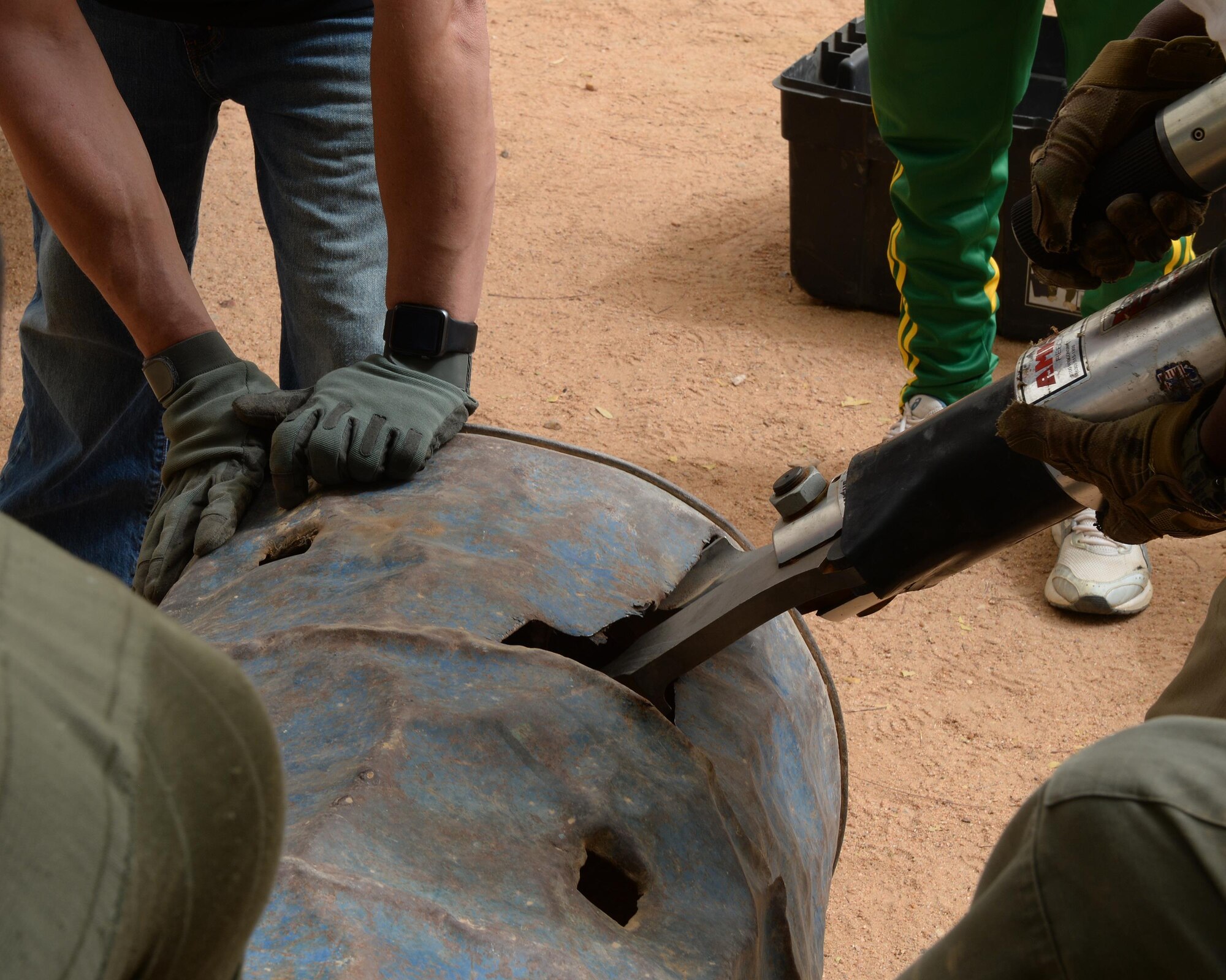 A combination spreader tool rips through a metal barrel in Agadez, Niger, May 16, 2017. The combination spreader tool is a hydraulic rescue tool, commonly referred to as the Jaws of Life, firefighters use to extricate a person trapped in an emergency situation. (U.S. Air Force photo by Senior Airman Jimmie D. Pike)