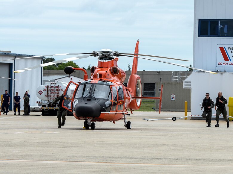 U.S. Coast Guard HH-65C Dolphin crew members from a U.S. Coast Guard Rotary Wing Air Intercept Squadron scramble to their helicopter for an intercept during a CrossTell training exercise at the Atlantic City International Airport, N.J., May 24, 2017. Air National units from New Jersey, South Carolina and Washington D.C. participated in training and familiarization exercises with the U.S. Coast Guard and Civil Air Patrol during the three-day CrossTell to increase awareness of the Aerospace Control Alert mission. (U.S. Air National Guard photo by Airman 1st Class Cristina J. Allen/Released)