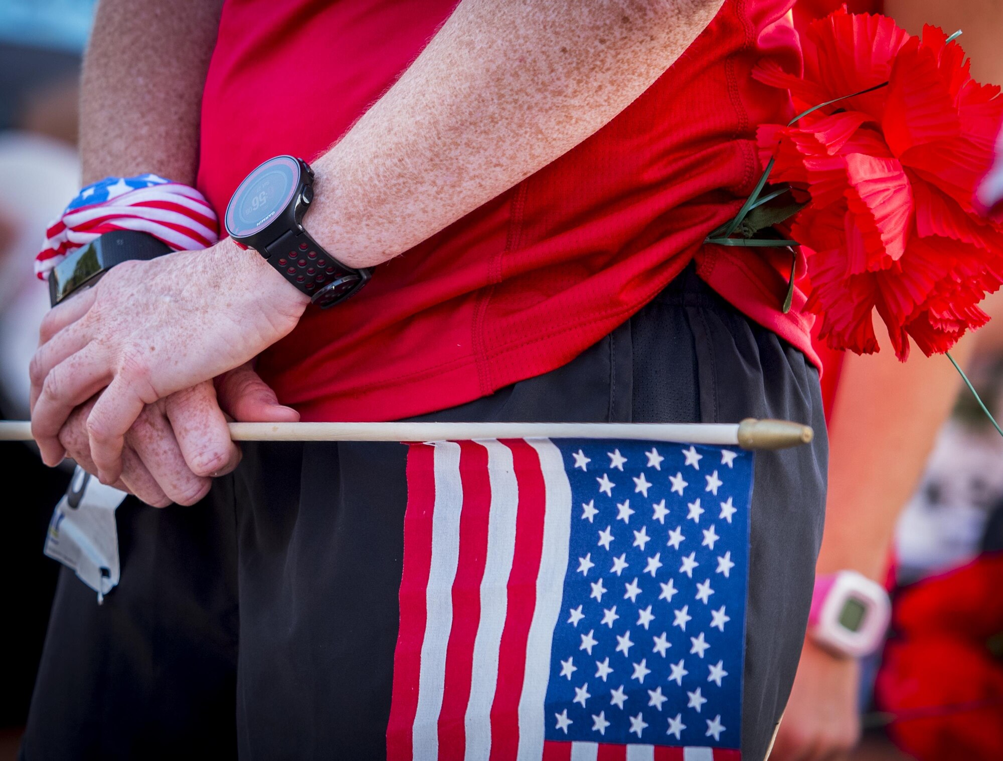 A runner holds an American flag and a red carnation prior to the 32nd annual Gate to Gate run at Eglin Air Force Base, Fla., May 27.  More than 900 people participated at this year’s event.  (U.S. Air Force photo/Samuel King Jr.)