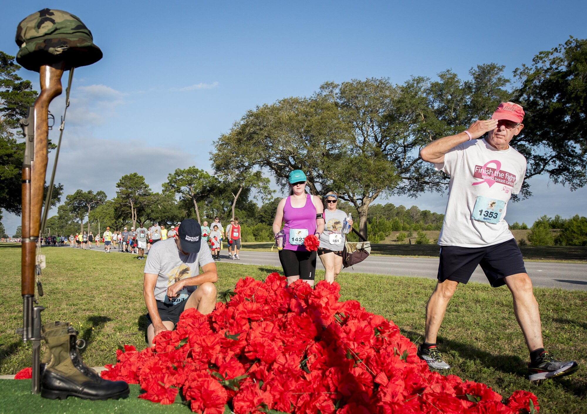 Runners salute, drop off a carnation or take a moment of reflection as they pass the All Wars Memorial during the Gate to Gate run at Eglin Air Force Base, Fla., May 27.  More than 900 people participated at this year’s event.  (U.S. Air Force photo/Samuel King Jr.)