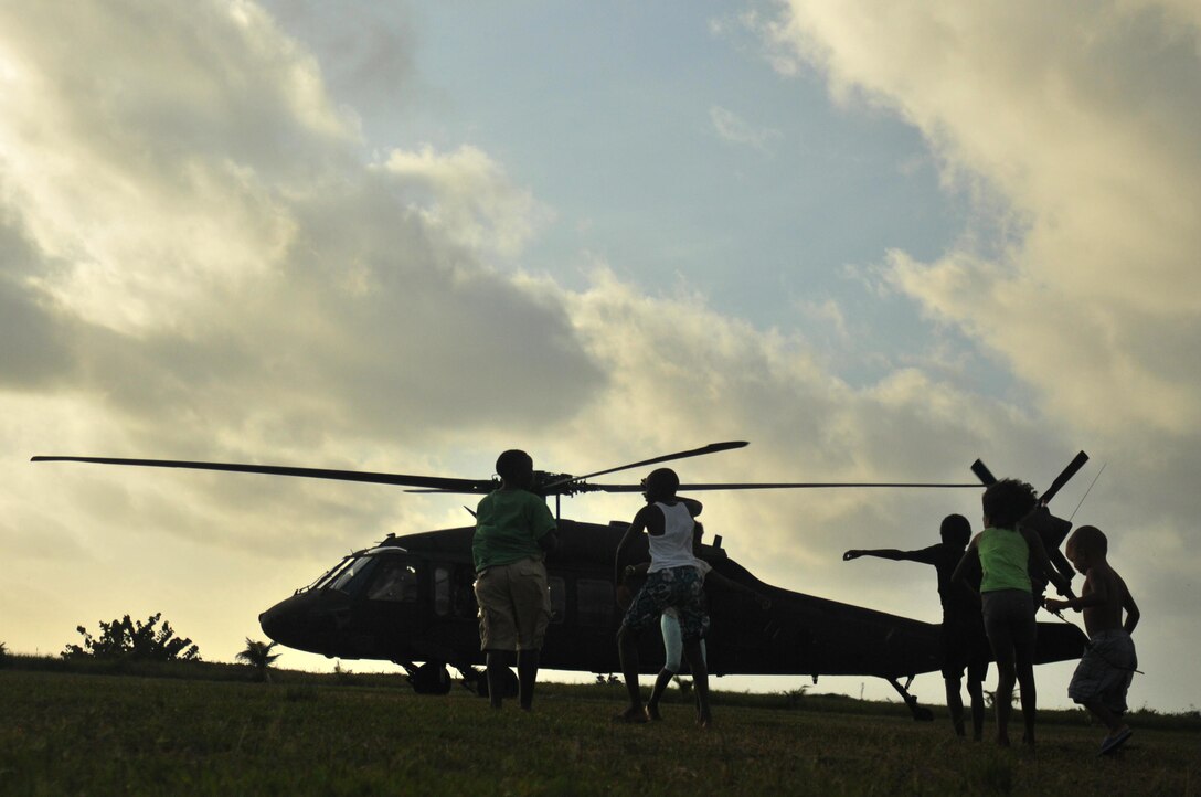 Local children run out to greet a UH-60 Blackhawk helicopter arriving for the medical readiness and training exercise held in Dangriga, Belize, May 22, 2017. The MEDRETE is one of three, carried out as part of Beyond the Horizon 2017, a U.S. Army South partnership exercise with the Government of Belize that consists of five construction projects and three health care events in communities across Belize. (US Army photo by Spc. Nathaniel Free)