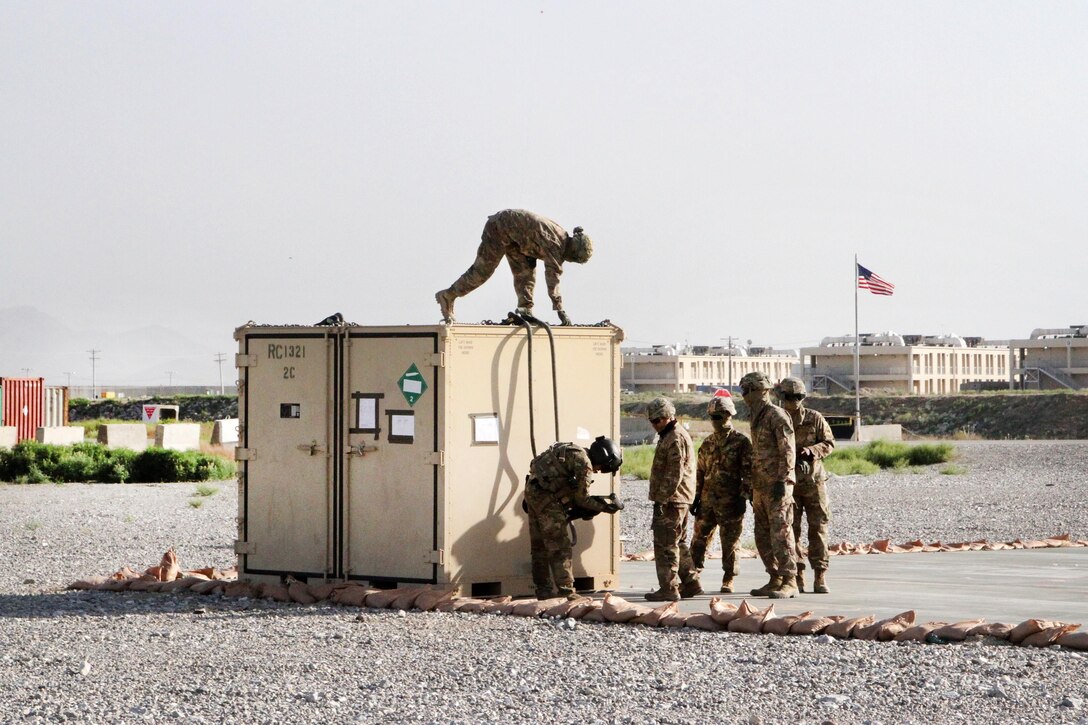 An Army crew chief instructs soldiers how to properly hook-up the cable from a container to a CH-47 Chinook helicopter during slingload operations at Bagram Airfield, Afghanistan, May 22, 2017. The soldiers are assigned to Task Force Muleskinner, and provide water, ammo, fuel, transportation, food and additional supplies to the warfighters and coalition forces in the brigade's area of operation and throughout the entire theater. Army photo by Sgt. 1st Class Shelia Cooper