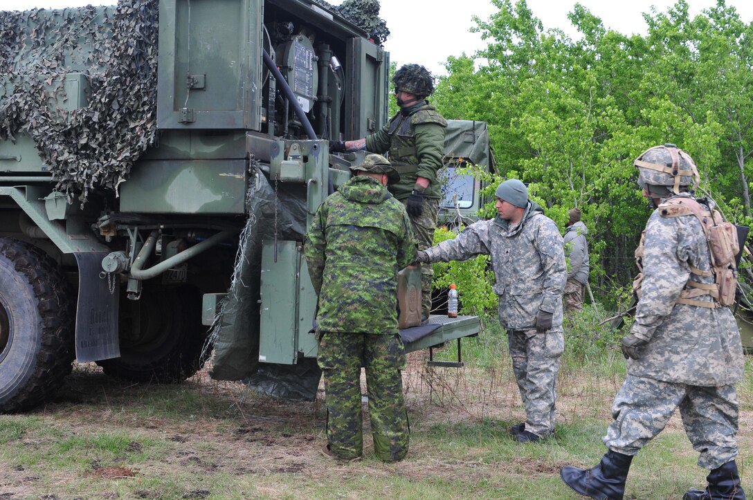 Soldiers from the Canadian Army’s 2 Field Ambulance service group fill a fuel can for Spc. Omar Rosario, a heavy wheeled vehicle operator from Avon Park, Florida, during Maple Resolve 17 at Camp Wainwright, Alberta, Canada, on May 24, 2017.  Rosario’s unit, the 993rd Transportation Company, provided logistical support during the joint training exercise designed to sharpen individual skill sets and enhance unit readiness. (U.S. Army photo by Sgt. Sarah Zaler)