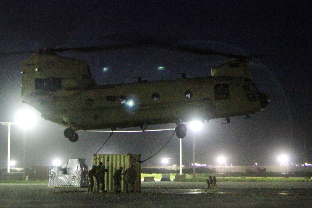 Soldiers hook-up a container to a CH-47 Chinook helicopter during night slingload operations at Bagram Airfield, Afghanistan, May 22, 2017. Army photo by Sgt. 1st Class Shelia Cooper
