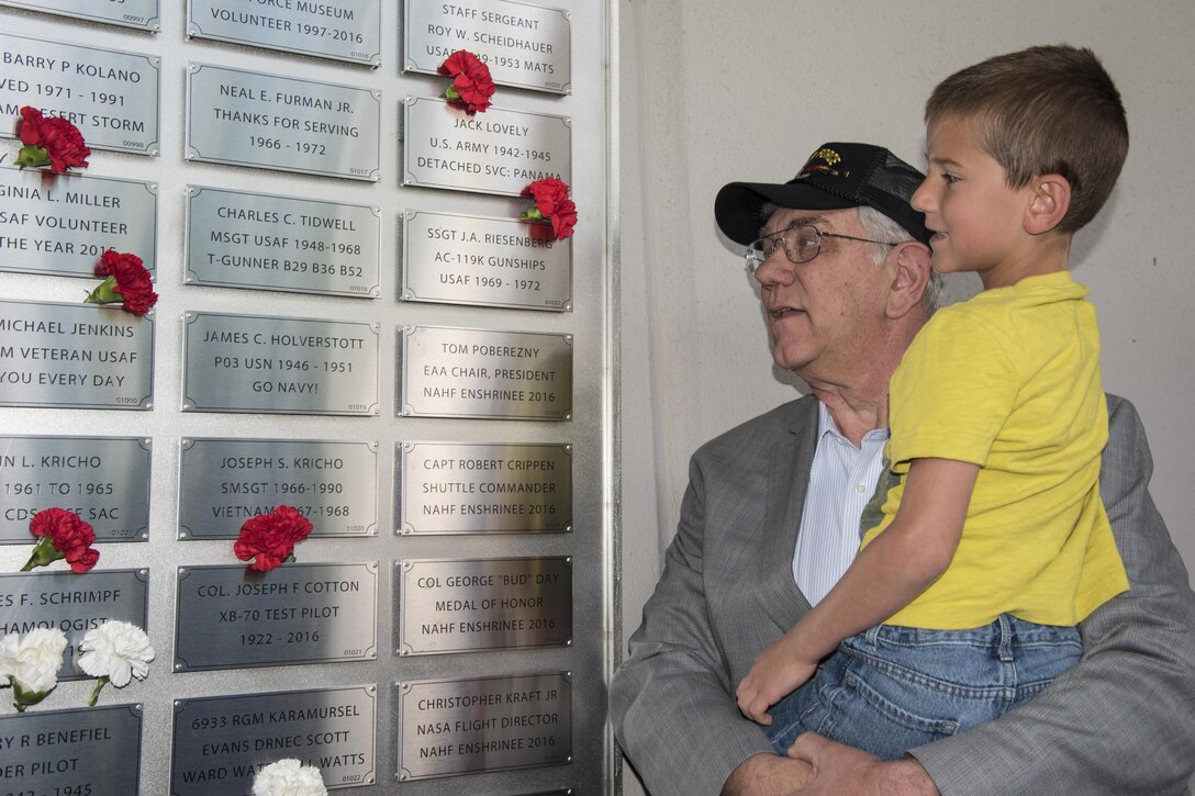 Vietnam Veteran Jerry Riesenberg and his Grandson Evan look upon the Legacy Data Plate Wall of Honor on May 25, 2017. Traditionally, all military aircraft have a data plate, which identifies the builder, and includes the aircraft model designation, serial number, and other important information. These Legacy Data Plates extend this tradition as a means to recognize and honor individuals.(U.S. Air Force photo by Ken LaRock)
