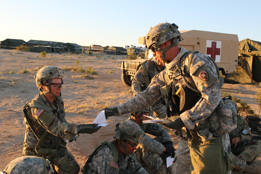 Army Chaplain (Capt.) Steven De Haan, with the Iowa Army National Guard’s 1034th Combat Sustainment Support Battalion, hands out a sheet of prayers at Fort Irwin, Calif., April 30, 2017. The unit is at the National Training Center for a three-week rotation. Iowa Army National Guard photo by Spc. Tawny Schmit