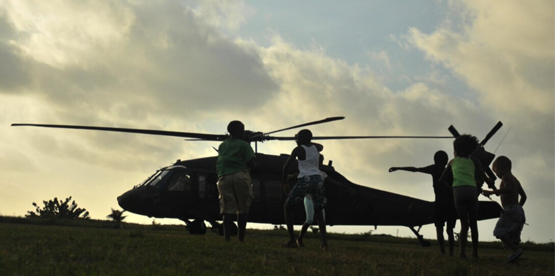 Local children run out to greet a UH-60 Blackhawk helicopter arriving for the medical readiness and training exercise held in Dangriga, Belize, May 22, 2017. The MEDRETE is one of three, carried out as part of Beyond the Horizon 2017, a U.S. Army South partnership exercise with the Government of Belize that consists of five construction projects and three health care events in communities across Belize. (US Army photo by Spc. Nathaniel Free)