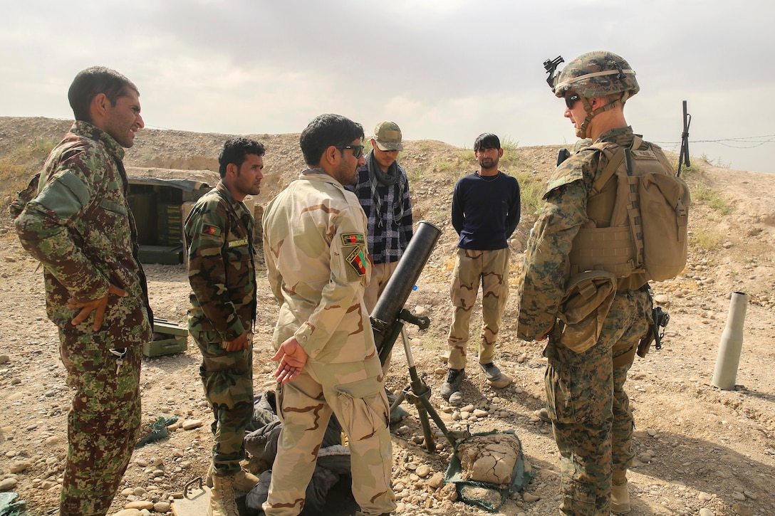 A U.S. Marine, right, inspects an 81 mm mortar with Afghan army soldiers at Camp Nolay, Afghanistan, May 22, 2017. Marine Corps photo by Sgt. Lucas Hopkins