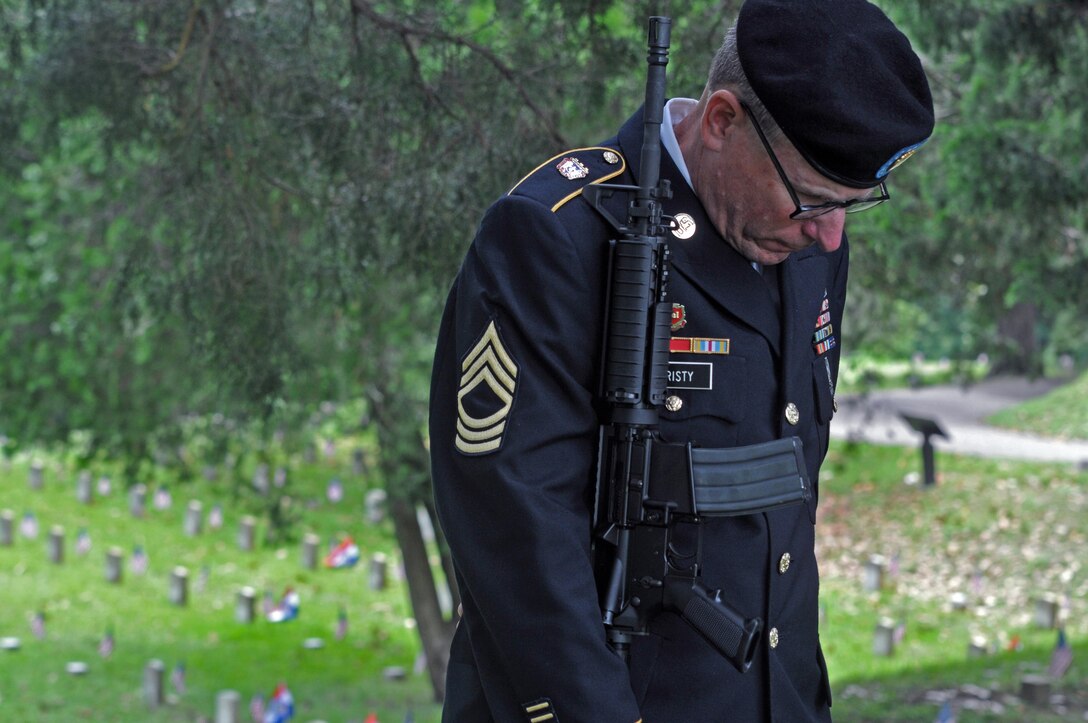 U.S. Army Reserve Master Sgt. Michael Christy, Headquarters and Headquarters Company, 412th Theater Engineer Command, based in Vicksburg, Miss., says a prayer before he and six other company soldiers performed a 21-gun salute at the Vicksburg National Cemetery Memorial Day Observance May 29, 2017. (U.S. Army Reserve Photo by Sgt. 1st Class Clinton Wood)