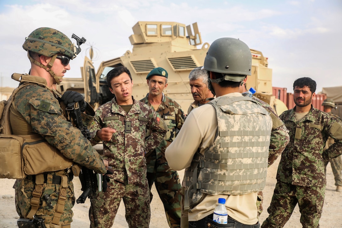 A U.S. Marine discusses vehicle repairs and improvements with Afghan soldiers at Camp Nolay, Afghanistan, May 22, 2017. Marine Corps photo by Sgt. Lucas Hopkins