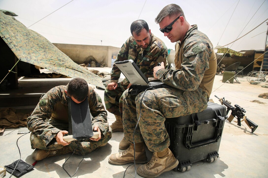 U.S. Marines and an Afghan soldier monitor a Raven unmanned aerial system at Camp Nolay, Afghanistan, May 23, 2017. Marine Corps photo by Sgt. Lucas Hopkins