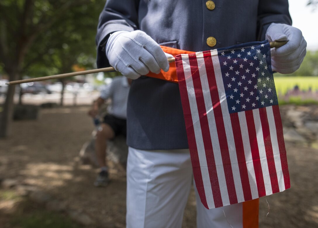 Clemson University Reserve Officers’ Training Corps cadet Chase McCathern holds a small American flag during a Memorial Day observance in Clemson’s Memorial Park, May 28, 2017. (U.S. Army Reserve photo by Staff Sgt. Ken Scar)