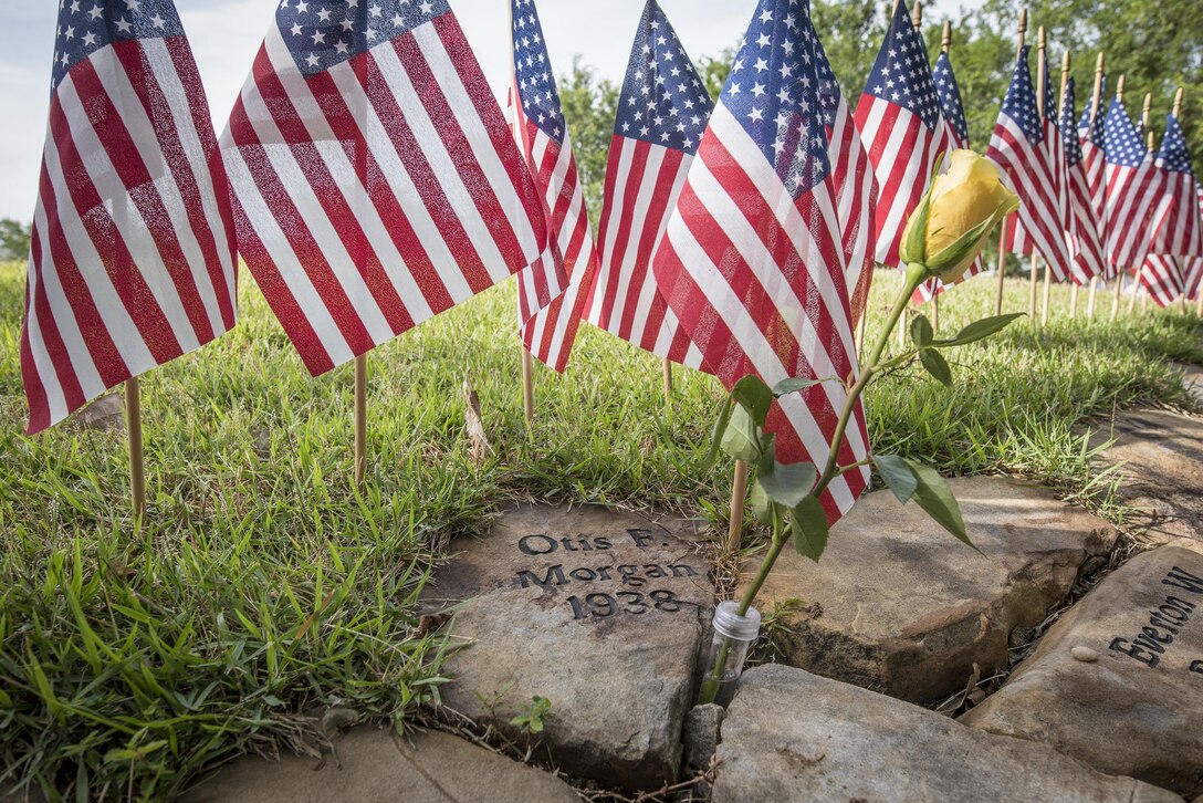 A yellow rose adorns the stone of Otis Morgan, who died during WWII, in Clemson University’s Scroll of Honor during a Memorial Day observance in Clemson’s Memorial Park, May 28, 2017. The Scroll of Honor is a grass-topped barrow with a ring of stones around it on which the names of every Clemson alumnus who gave the ultimate sacrifice are etched. There are currently 491 of them. (U.S. Army Reserve photo by Staff Sgt. Ken Scar)