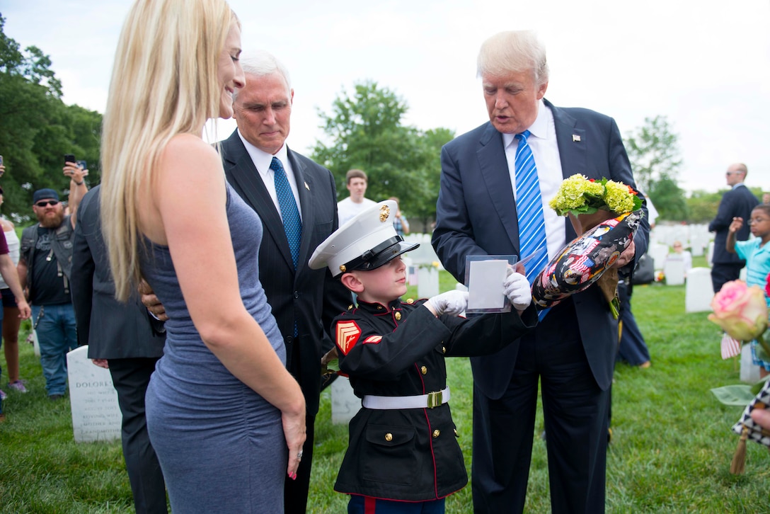 President Donald J. Trump and Vice President Mike Pence talk with Christian, 6, and his mother Brittany Jacobs at the grave of Christian's father in Section 60 of Arlington National Cemetery on Memorial Day, May 29, 2017, in Arlington, Va. Army photo by Elizabeth Fraser