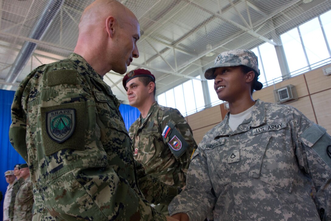 Croatian Command Sgt. Maj. Davor Petek, the command senior enlisted leader for allied command operations at NATO’s Supreme Headquarters Allied Powers Europe, greets U.S. Army Pfc. Angel Anderson, at KFOR headquarters at Camp Film City in Pristina, Kosovo, Sept. 4, 2015. Army photo by Sgt. Erick Yates