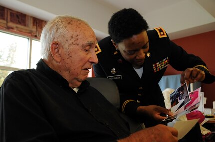 Maj. Angela Reed-Johnson, strategic operations chief for the Directorate of Human Resources for the U.S. Army Reserve’s 99th Regional Support Command at Joint Base McGuire-Dix-Lakehurst, New Jersey, visits May 26 with Dominic Ieropoli at the Veterans Memorial Home in Vineland, New Jersey.  Ieropoli is showing off photos from the 99th RSC’s dining out on May 12, an event to which dozens of residents from the home were invited.