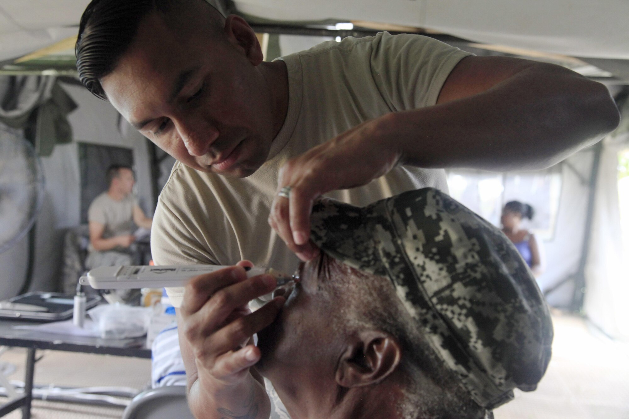 U.S. Air Force Tech Sgt. Benjamin Lemus, 96th Medical Group, checks the pressure of a patient's eye at a medical readiness event in Dangriga, Belize, May 22, 2017. This is the third and final medical event for Beyond the Horizon 2017, a U.S. Southern Command-sponsored, Army South-led exercise designed to provide humanitarian and engineering services to communities in need, demonstrating U.S. support for Belize. (U.S. Army photo by Spc. Kelson Brooks)