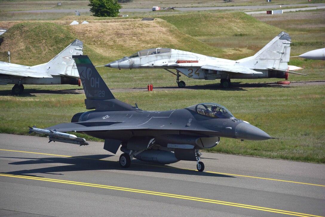 Ohio Air National Guard Air Force Lt. Col. Chad Holesko taxis by MiG 29 aircraft before taking off on a training mission during exercise Load Diffuser 17 at Kecskemet Air Base, Hungary, May 26, 2017. Holesko is a pilot assigned to the Ohio Air National Guard’s 180th Fighter Wing. Air National Guard photo by Air Force Senior Master Sgt. Beth Holliker