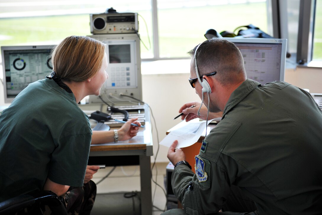 Ohio Air National Guard Air Force Capt. Justin Kreischer, right, works alongside Hungarian air force 1st Lt. Krisztina Kovacs inside the control tower during exercise Load Diffuser 17 at Kecskemet Air Base, Hungary, May 26, 2017. Kreischer is a pilot assigned to the Ohio Air National Guard’s 180th Fighter Wing. Kovacs is a ground controller. Air National Guard photo by Air Force Senior Master Sgt. Beth Holliker