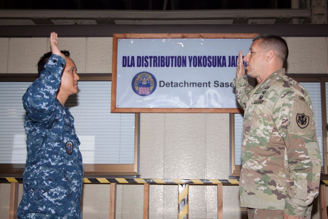 Army Brig. Gen. John S. Laskodi, DLA Distribution commanding general, hosted a reenlistment ceremony for material management noncommissioned officer Navy Logistics Specialist 1st Class Juliber C. Fernandez on May 16 at DLA Distribution Sasebo, Japan.