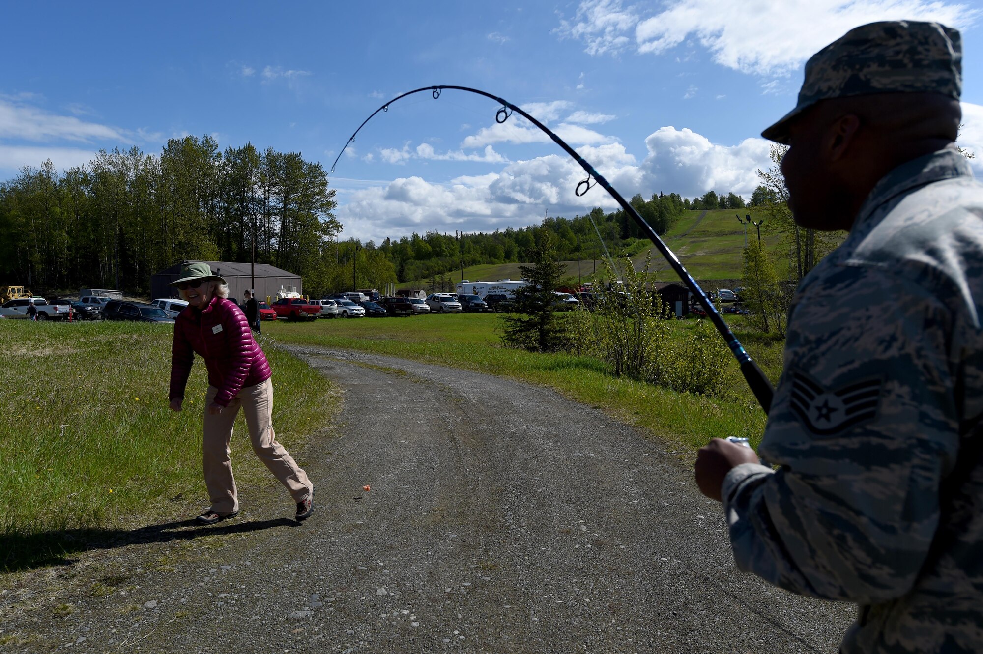 U.S. Air Force Staff Sgt. Daniel Shobe, 773d Logistics Readiness Squadron non-commissioned officer in charge of training and validation, casts his line as Jan Schnorr, Project Healing Waters co-director, simulates a caught fish during Safety Day at the Hillberg stables at Joint Base Elmendorf-Richardson, Alaska, May 25, 2017. Field experts on all-terrain vehicles, kayaking, hiking, mountain biking, archery, and fly fishing provided hands-on demonstrations and briefings for Safety Day. 