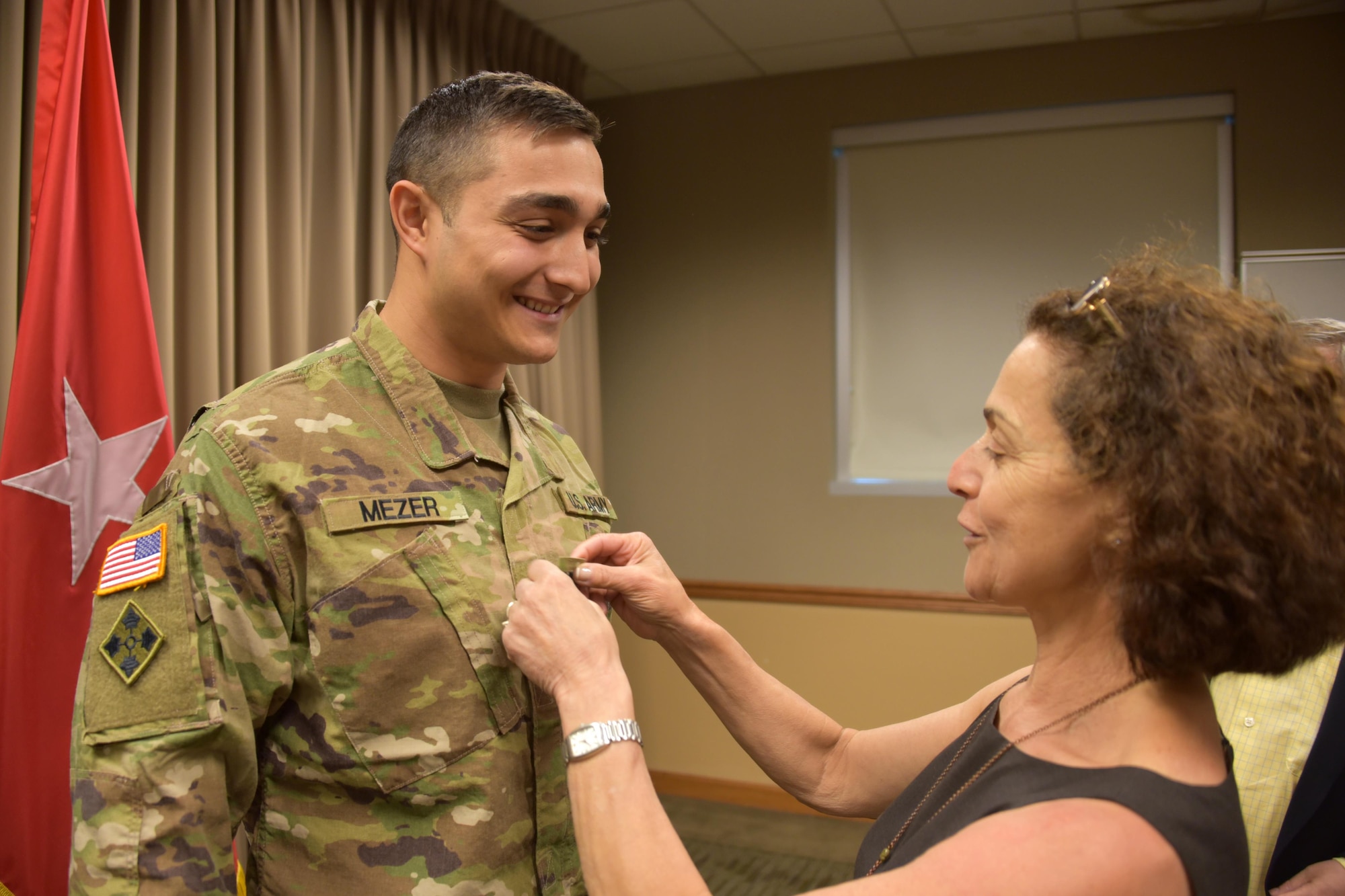 Capt. Matthew Mezer receives his new rank from his mom, Eleanor Mezer, during a promotion ceremony May 23 at U.S. Army Space and Missile Defense Command/Army Forces Strategic Command's Peterson Air Force Base, Colo., headquarters. (U.S. Army photo by Dottie White)