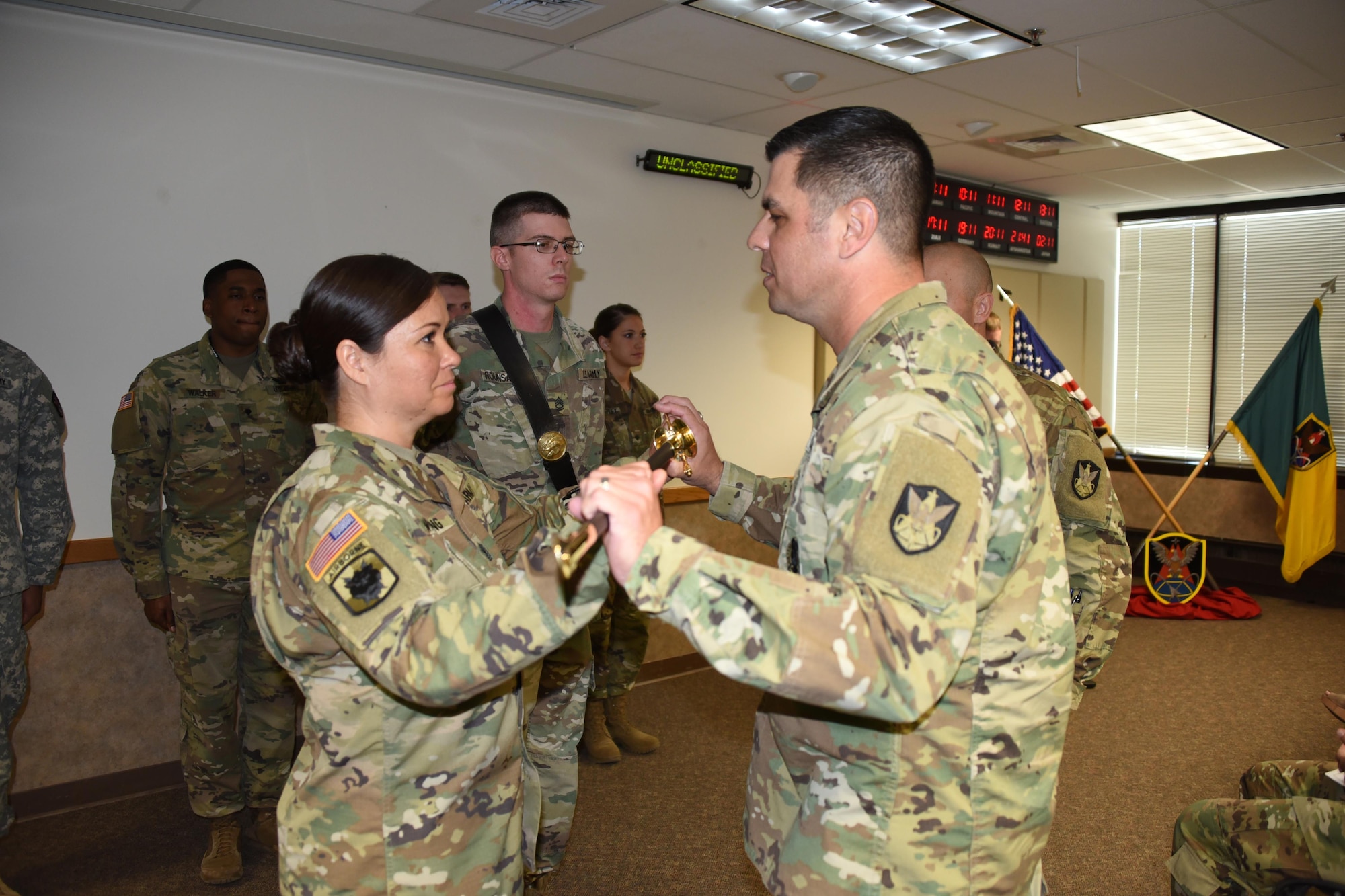 Command Sgt. Maj. Scott J. Sutherland, 1st Space Brigade, U.S. Army Space and Missile Defense Command/Army Forces Strategic Command, passes the U.S. Army noncommissioned officer sword to 1st Sgt. Carolyne T. Wilding signifying her new responsibilities as the incoming first sergeant for Headquarters and Headquarters Company, 1st Space Brigade. The Change of Responsibility from outgoing 1st Sgt. Kelly M. Hart took place May 24 in Colorado Springs, Colo. (U.S. Army photo by Dottie White)
