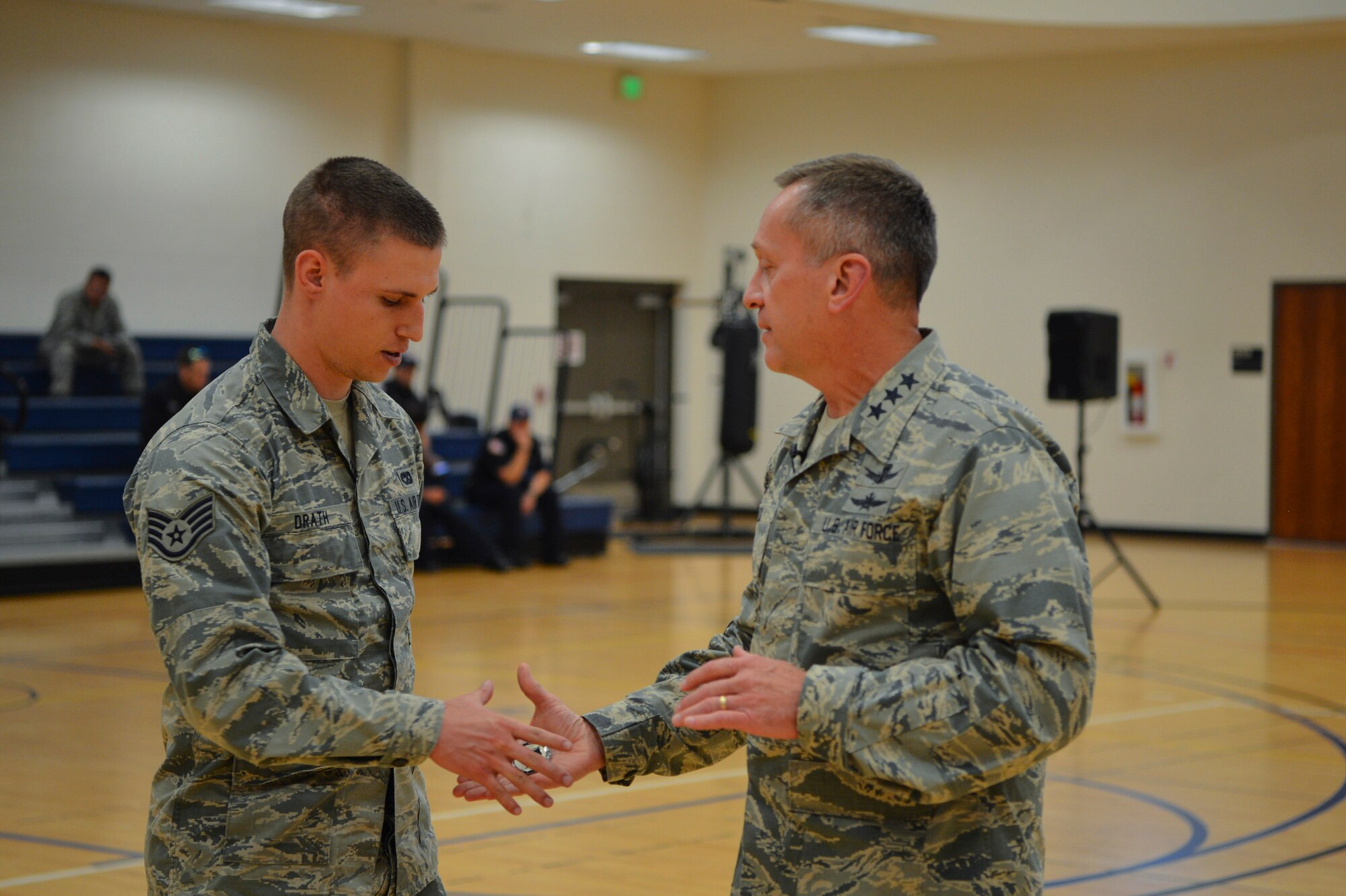 Lt. Gen. David J. Buck, Commander, 14th Air Force (Air Forces Strategic), Air Force Space Command; and Commander, Joint Functional Component Command for Space, U.S. Strategic Command,coins Staff Sgt. Nicholas Drath, 460th Logistics Readiness Squadron NCO in charge of traffic management, during a commander’s call May 23, 2017, on Buckley Air Force Base, Colo. Drath was coined for his outstanding work running the base traffic management office on his own. (U.S. Air Force photo by Airman 1st Class Holden S. Faul/ Released)