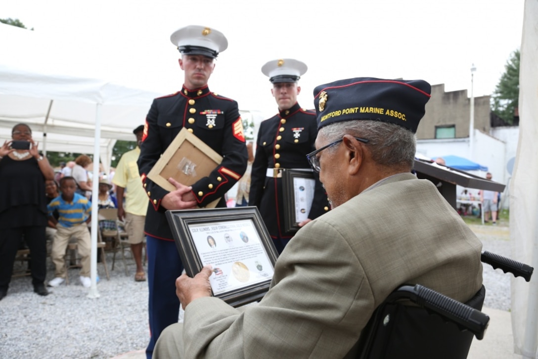 Archibald Mosley reads a Congressional Gold Medal memento for Montford Point Marines, May 27, at the Colp Area Veterans Celebration, Dedication and Remembrance Ceremony, in Colp, Illinois. Nearly 20,000 African-Americans joined the Marine Corps in 1942, after President Franklin D. Roosevelt issued a “presidential directive giving African Americans an opportunity to be recruited in the Marine Corps,” according to the Montford Point Marines Association website. They didn’t receive recruit training at San Diego or Parris Island, however, but Camp Montford Point, N.C., a segregated training site for African American Marine recruits. For the next seven years, the camp remained opened until it became desegregated. The four Marines are Sol Griffin, Jr.; James L. Kirby, Early Taylor, Jr. and Archibald Mosley. These Marines, among many other Montford Point Marines across the country, were awarded the Congressional Gold Medal, the highest award that can be given to a civilian by Congress, in 2012. Mosley is one of four Montford Point Marines from Colp. (U.S. Marine Corps photo by Gunnery Sgt. Bryan A. Peterson) 