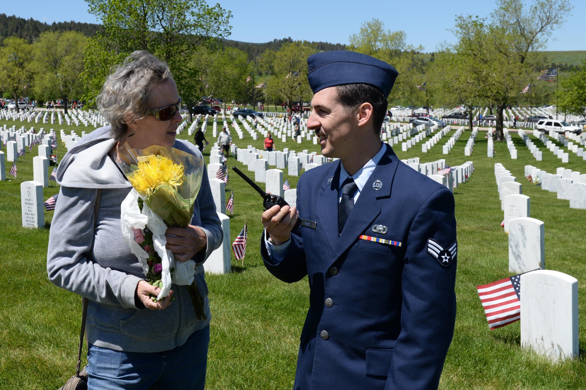 Senior Airman Joseph, an intelligence analyst assigned to the 89th Attack Squadron, helps a spouse locate her husband buried at the Black Hills National Cemetery, S.D., May 29, 2017. Over 180 Airmen volunteered to help locate the tombstones of family members for Memorial Day weekend. (U.S. Air Force Photo by Airman Nicolas Z. Erwin)