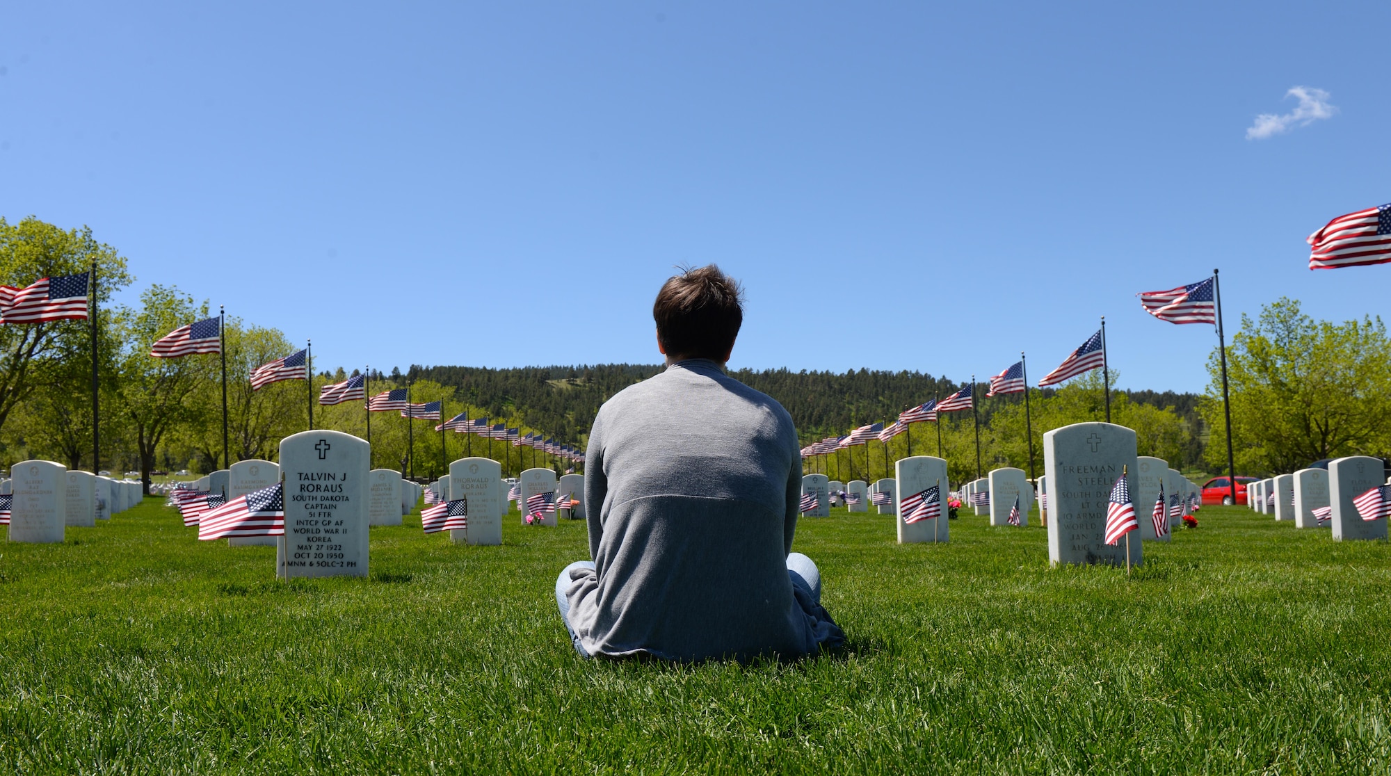 Staff Sgt. Sarah Denewellis, a broadcast journeyman assigned to the 28th Bomb Wing Staff, honors fallen service members during Memorial Day at the Black Hills National Cemetery, S.D., May 29, 2017. Ellsworth Airmen honored their fallen brethren by directing traffic, helping families find gravesites of loved ones, or taking the time to sit with visitors and remember the sacrifices and successes of the fallen. (U.S. Air Force photo by Airman Nicolas Z. Erwin)