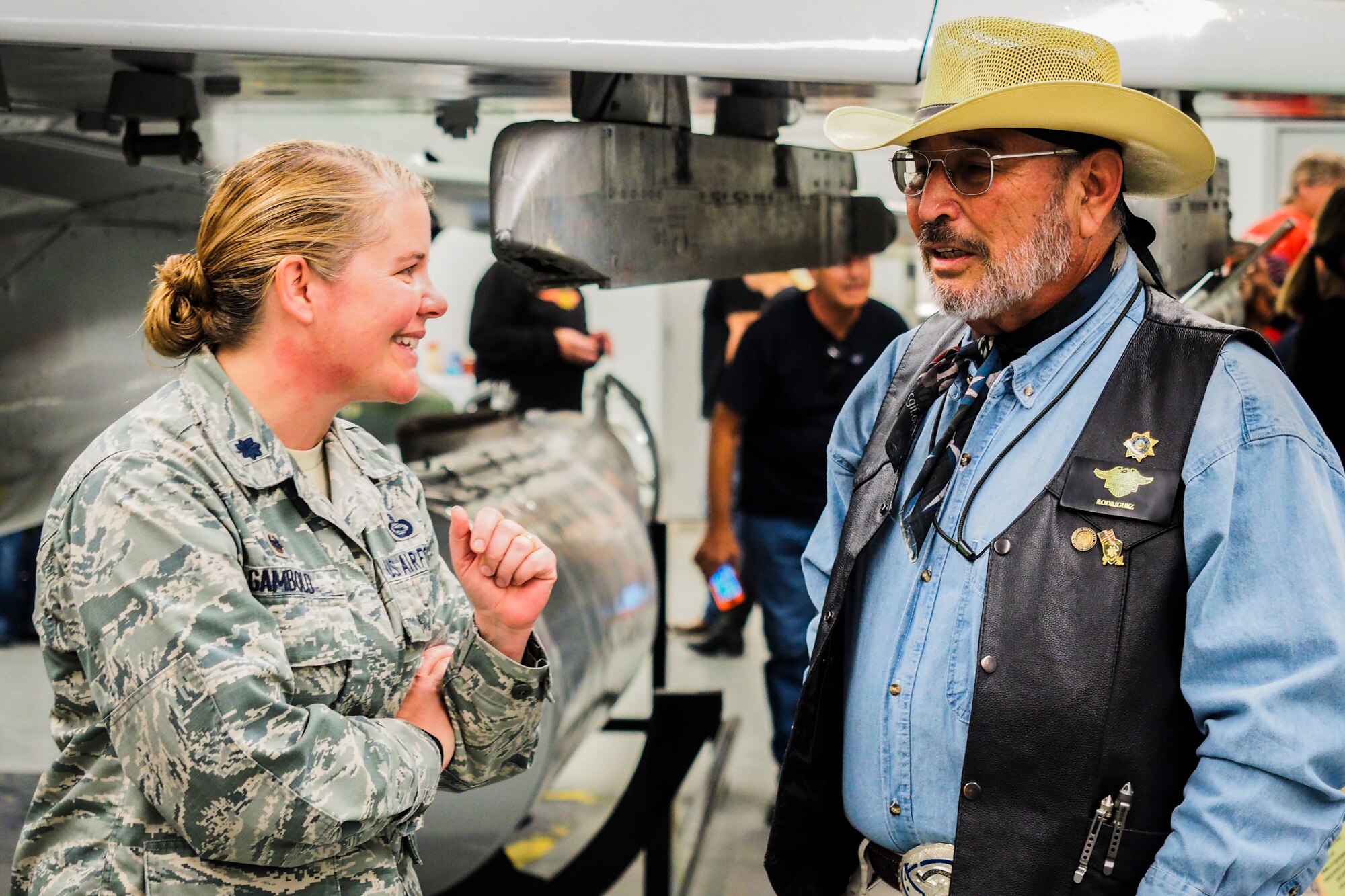 Lt. Col. Catherine Gambold, 547th Intelligence Squadron commander, speaks with a biker at the Air Combat Command Threat Training Facility at Nellis Air Force Base, Nev., May 21, 2017. The TTF maintains weapons and equipment to be used as training aids. Now that the TTF is open to the public, visitors can view anything from MiG fighter jets, to rocket propelled grenades. (U.S. Air Force photo by Master Sgt. Heidi West/Released)