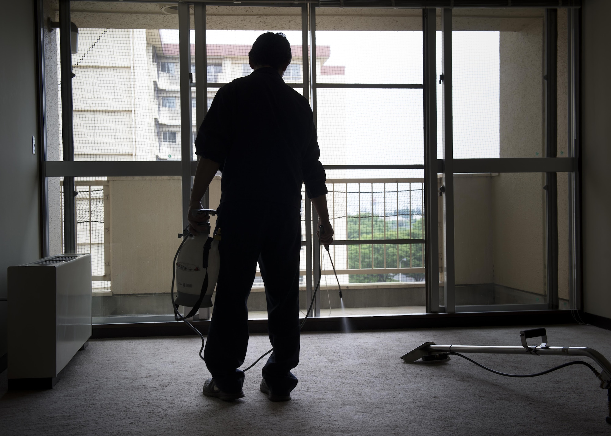 A contractor sprays a cleaning solution in an unoccupied unit of a contingency tower, May 18, 2017, at Yokota Air Base, Japan. These contingency towers allow the installation commander to temporarily open contingency quarters to accommodate large influxes of en-route, deployed or TDY personnel resulting from routine, emergency or wartime conditions. (U.S. Air Force photo by Airman 1st Class Juan Torres)
