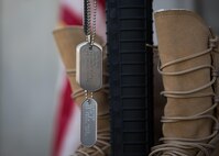 Dog tags, displaying the names of Airmen killed in action, hang off of a rifle during a Memorial Day ceremony at Bagram Airfield, Afghanistan, May 29, 2017. The boots, rifle and helmet make what is called the Battlefield Cross, which is a symbolic replacement of a cross and is used to honor and show respect to deceased service members. (U.S. Air Force photo by Staff Sgt. Benjamin Gonsier)