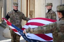 Bagram Honor Guard members unfold the American flag during a Memorial Day ceremony at Bagram Airfield, Afghanistan, May 29, 2017. During the ceremony, Bagram Airmen portrayed three fallen comrades, telling the story of how they made the ultimate sacrifice. (U.S. Air Force photo by Staff Sgt. Benjamin Gonsier)