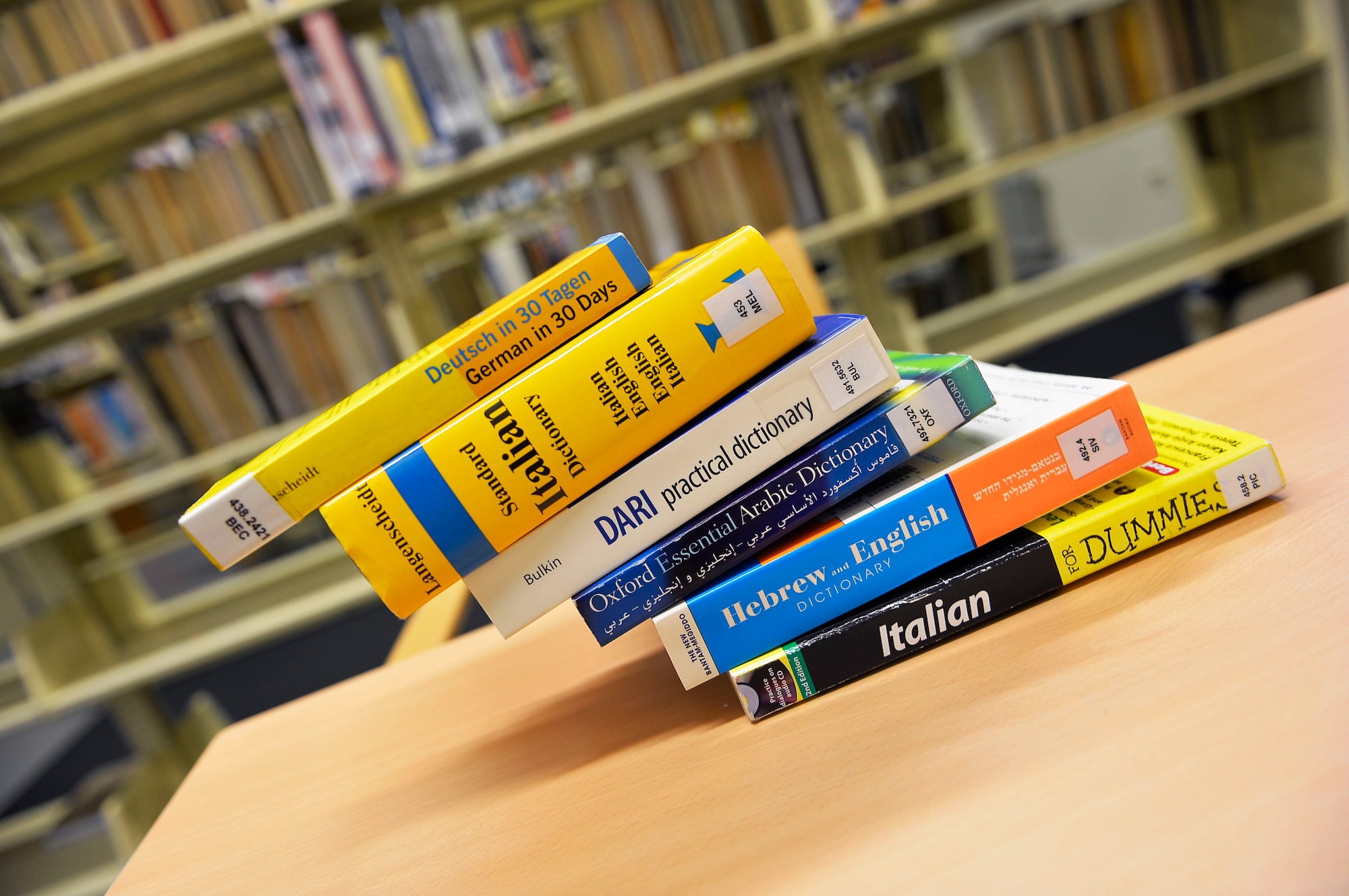 Books about learning foreign languages create the illusion of falling off a table in a library at Ramstein Air base, Germany, May 18, 2017. The Language Enabled Airman Program aims to develop a general purpose force comprised of multi-lingual Airmen from all Air Force specialties. (U.S. Air Force photo by Airman 1st Class Joshua Magbanua)